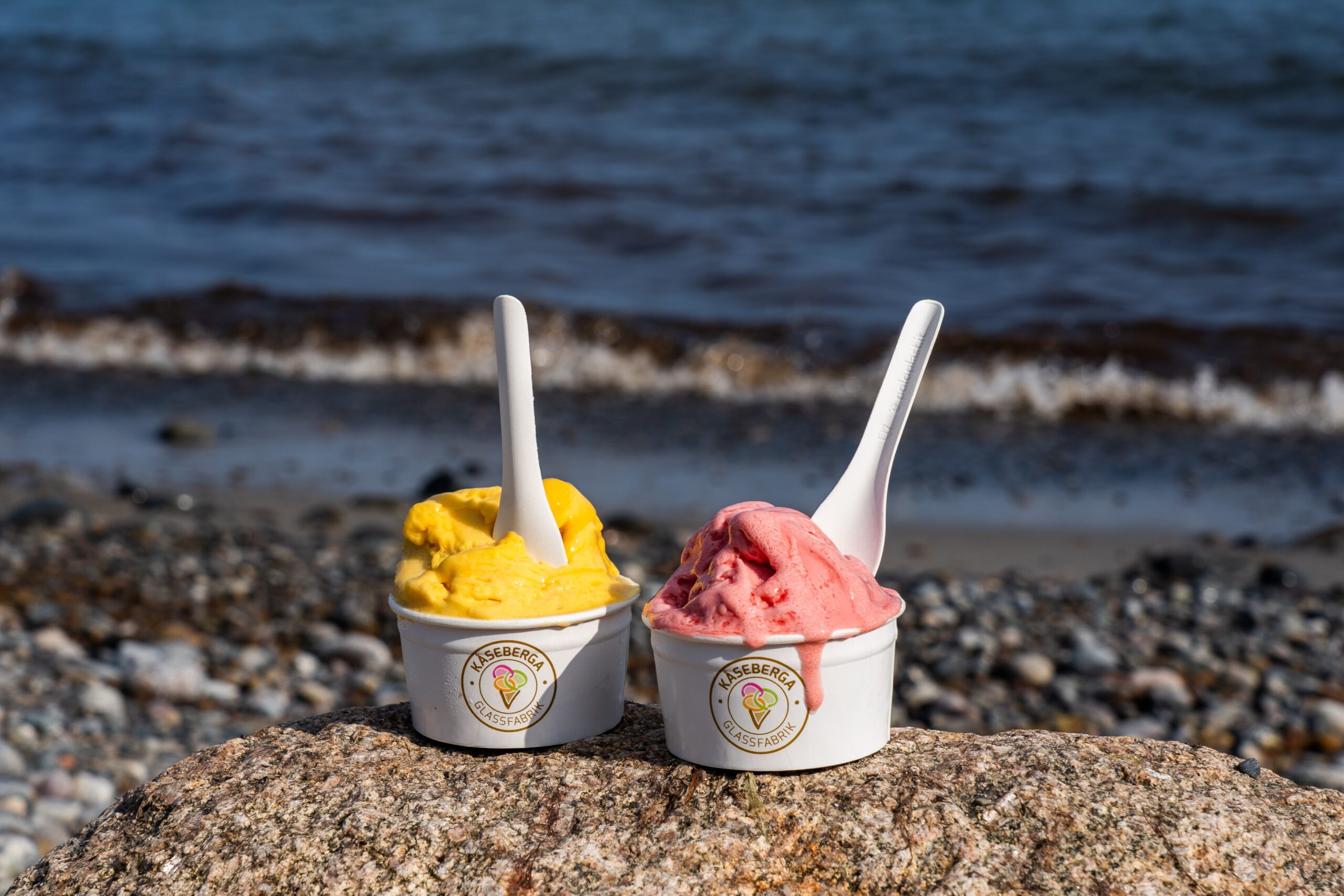 Glassbägare på stranden med havet bakom